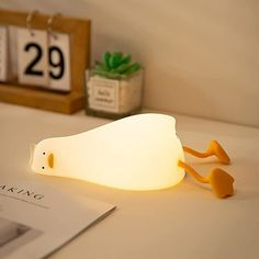 a white light sitting on top of a table next to a calendar and a book