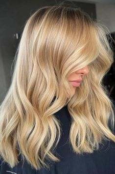 This rich butter blonde hairstyle has lots of soft, natural-looking waves that give it a nice look of movement. The warm, creamy colors of the dye blend together really well, making the hair's texture and volume look fuller. With some subtle lighter pieces and how the stylist cut it into nice layers, this style is very - Click to see more of Get Inspired: 30 Stunning Butter Blonde Hair Ideas You Can't Resist and follow us for more hairstyle ideas. // Photo Credit: Instagram @the.mane.collective Summer Honey Blonde, Warm Honey Blonde Highlights, Partial Balayage Blonde, Bright Golden Blonde, California Blonde Hair Sun Kissed, Wheat Blonde, Butter Blonde Hair, Warm Blonde Hair, Blonde Lowlights