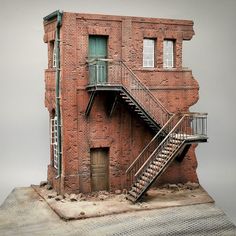 a model of a brick building with stairs leading up to the door and second story