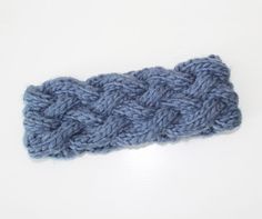 a blue knitted headband on a white surface