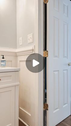 an open door in a white bathroom next to a sink