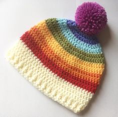 a multicolored knitted hat with a pom - pom on top