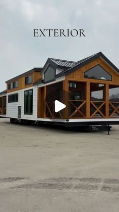 a small house sitting on top of a trailer in an empty lot with the words exterior above it