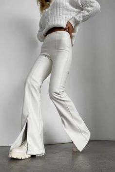 Feel like a goddess in these white split-front flare leather pants! Made from vegan leather, these pants are soft, stretchy, and comfortable. The high waist and flare leg make them flattering on all body types. The front split adds a touch of edge, while the side zipper makes them easy to put on and take off. These pants are perfect for any occasion, from a night out to a day at the office. Pair them with a crop top and heels for a sexy look or a sweater and boots for a more casual look. Made from vegan leather Soft, stretchy, and comfortable High waist Flare leg Front split hem Pull-on style Side zipper Available in white and black Chic White Bottoms With Side Slits, White Fitted Bottoms With Split Design, Fitted White Bottoms With Split Design, Fitted White Bottoms With Split, Flare Leather Pants, White Leather Pants, Glitter Jumpsuit, Vegan Leather Pants, Neon Dresses