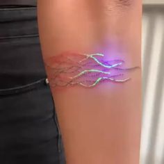 a woman's arm with a glowing bracelet on it