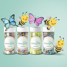 three jars filled with sprinkles next to two bees and a butterfly on top