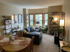 a living room filled with furniture and a dining table in front of a fire place