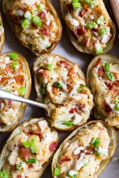 baked potato skins with cheese, bacon and green onions on a baking sheet ready to be eaten