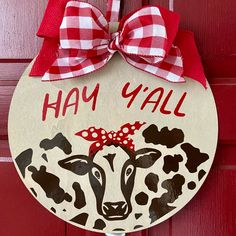 a wooden sign that says hay y'all with a cow painted on the front