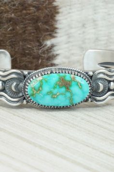 This Sonoran Gold turquoise and sterling silver bracelet was made by Navajo silversmith Delbert Gordon. The inside is signed D. Gordon and stamped sterling.Size: 5 3/4" (will fit up to a 7" wrist)Gap: 1 1/4"Width: 5/8"Free shipping on all orders! We ship with USPS and always include tracking. All orders ship within a day of payment.Returns are accepted up to 30 days after you receive your order. Just send us a message. Our shop offers cash back or store credit. The item must be returned in new c Southwestern Style Sterling Silver Turquoise Bracelet, Western Silver Bracelet With Patina, Southwestern Stamped Turquoise Sterling Silver Bracelet, Southwestern Turquoise Stamped Sterling Silver Bracelet, Southwestern Style Turquoise Bracelet Stamped 925, Southwestern Style Stamped Turquoise Bracelets, Southwestern Style Turquoise Stamped Bracelets, Turquoise Sterling Silver Bracelet With Patina, Western Style Turquoise Stamped Bracelets