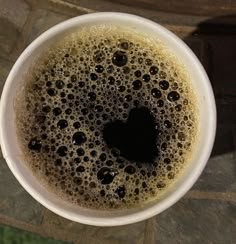 a white cup filled with liquid on top of a table