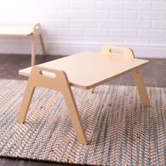 two wooden children's desks sitting on top of a rug