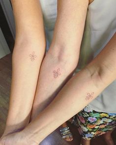 two women with matching tattoos on their legs, both holding each other's hands