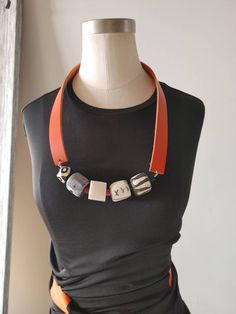 This juicy necklace will absolutely 10x any outfit. Smooth bold orange leather forms the chain.... The front features all forms of chunky funky bone beads in gray beige and black and white. Nestled in between the bone beads are splashes of black african vulcanite as well as fuchsia ....this necklace is perfect for people who have metal allergies on the neck Leather Necklace Ideas, Juicy Necklace, Pottery Jewellery, African Beaded Necklace, Leather Beaded Necklace, Boho Beaded Necklace, African Beads Necklace, Diy Jewellery Designs, Artisan Jewelry Handmade