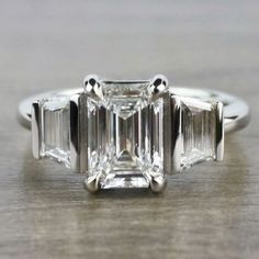 an emerald cut diamond ring with three baguets