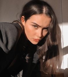 a woman with long hair is posing for the camera