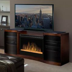 a living room with a large television and fire place in front of the tv screen