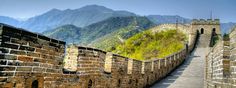 the great wall of china is built on top of it's own sides, with mountains in the background