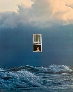 an image of a man looking out the window at the ocean from inside his house