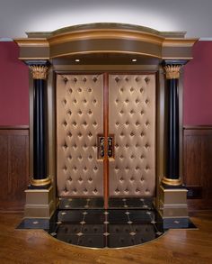 an elaborately designed entryway with two columns and a door that is surrounded by black pillars