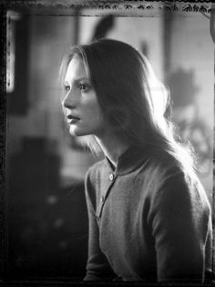 black and white photograph of a woman with long hair looking off to the side in an old photo