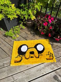 a rug that looks like the face of adventure time is shown on a wooden deck