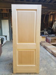 an unfinished wooden door in a workshop