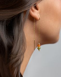 Add a touch of vibrant elegance to your look with these stunning Green Peridot and Carnelian Agate Chain Earrings. The dangle design creates movement and style, making them perfect for any occasion. The combination of the rich green peridot and the fiery orange carnelian agate stones creates a unique and eye-catching color contrast. These earrings are versatile and can easily be dressed up or down, making them a must-have addition to your jewelry collection. Handcrafted with care, they are sure to add a pop of color and sophistication to your outfit. DETAILS  These are natural gemstones. Hanging from a 24K gold-plated sterling silver threader chain, the stones are natural, a delicate faceted peridot accompanied by a round-cut .  MATERIALS AND SIZE Solid Sterling Silver 24k Yellow Gold Plat Carnelian Agate, Orange Carnelian, Dangle Earrings Boho, Earrings Stone, Green Peridot, Threader Earrings, Vibrant Green, Earrings Boho, Color Contrast