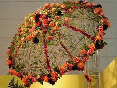 an umbrella decorated with flowers and greenery