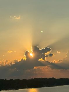 the sun is shining through clouds over water