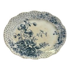 a blue and white plate with flowers on the rim, sitting against a white background