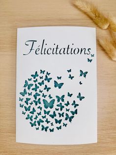 a greeting card with butterflies on it and the words felicetations written in cursive ink