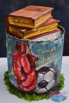 a cake made to look like a book with boxing gloves on top and a soccer ball in the middle