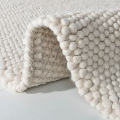 a close up of a white rug with balls on the bottom and inside of it