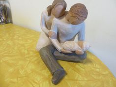 a statue of two people sitting on top of a table