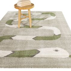 an area rug with green and white circles on it, next to a wooden stool