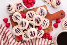 raspberry shortbreads with white chocolate drizzled on them and fresh raspberries