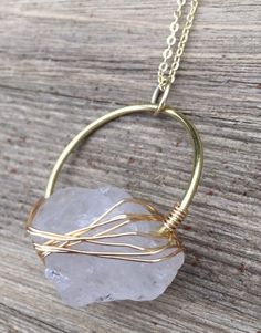 "*MADE TO ORDER* by a one-woman operation -- please allow 1-2 weeks for production. A circle of thick gold or silver-tone wire pierces a wire-wrapped raw clear quartz nugget. Pendant hangs on a matching gold-plated or stainless steel chain. If you choose, the lobster clasp can be bookended by handmade lava diffuser beads - just select the \"with\" lava diffuser beads option at checkout. Pendant length: 2\"  Length: 26\" (lava bead + clasp adds 2 ¼\" to length) *PLEASE NOTE: Crystals and stones are unique -- like people, no two are exactly alike. Please allow for some variation in color, shape, and size. Thank you!" Raw Clear Quartz, Tibetan Quartz, Clear Quartz Necklace, Quartz Pendant Necklace, Sterling Necklaces, Lava Bead, Custom Earrings, A Circle, Quartz Necklace