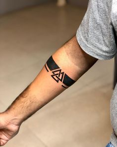 a man's arm with a tattoo on it and a black arrow in the middle