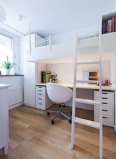 a white loft bed with desk and chair in a room that has hardwood flooring