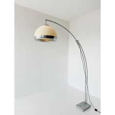 a lamp that is on top of a white floor next to a wall with a light in it