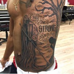 a man with a back tattoo that says only the strong survive