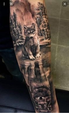 a man's arm with an image of two wolfs and a lake on it