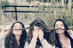 three women with long hair are holding their hands up to their faces