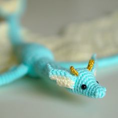 a small blue and white toy lizard sitting on top of a table