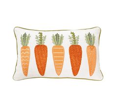 three carrots embroidered on a white pillow