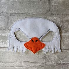 a white mask with an orange beak on it