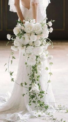 a woman in a wedding dress holding a bouquet of flowers