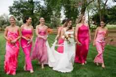 a group of women standing next to each other on top of a lush green field