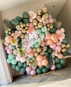 a happy birthday balloon arch with gold, green and pink balloons